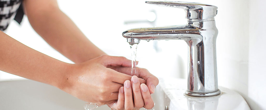 woman washing hands in clean water